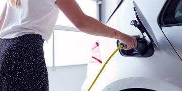 Woman charging electric vehicle